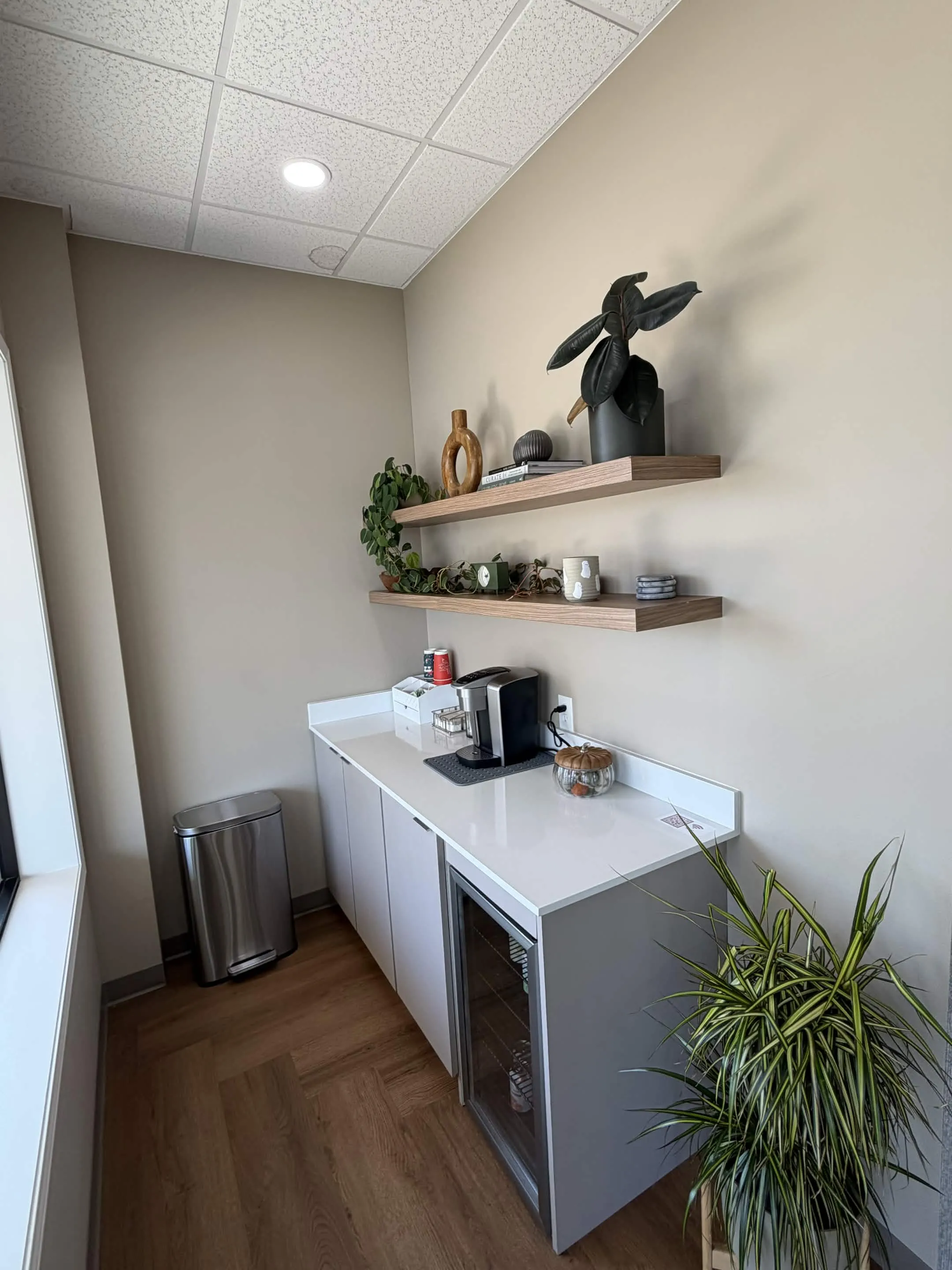 Complimentary coffee station with plants and wooden shelves