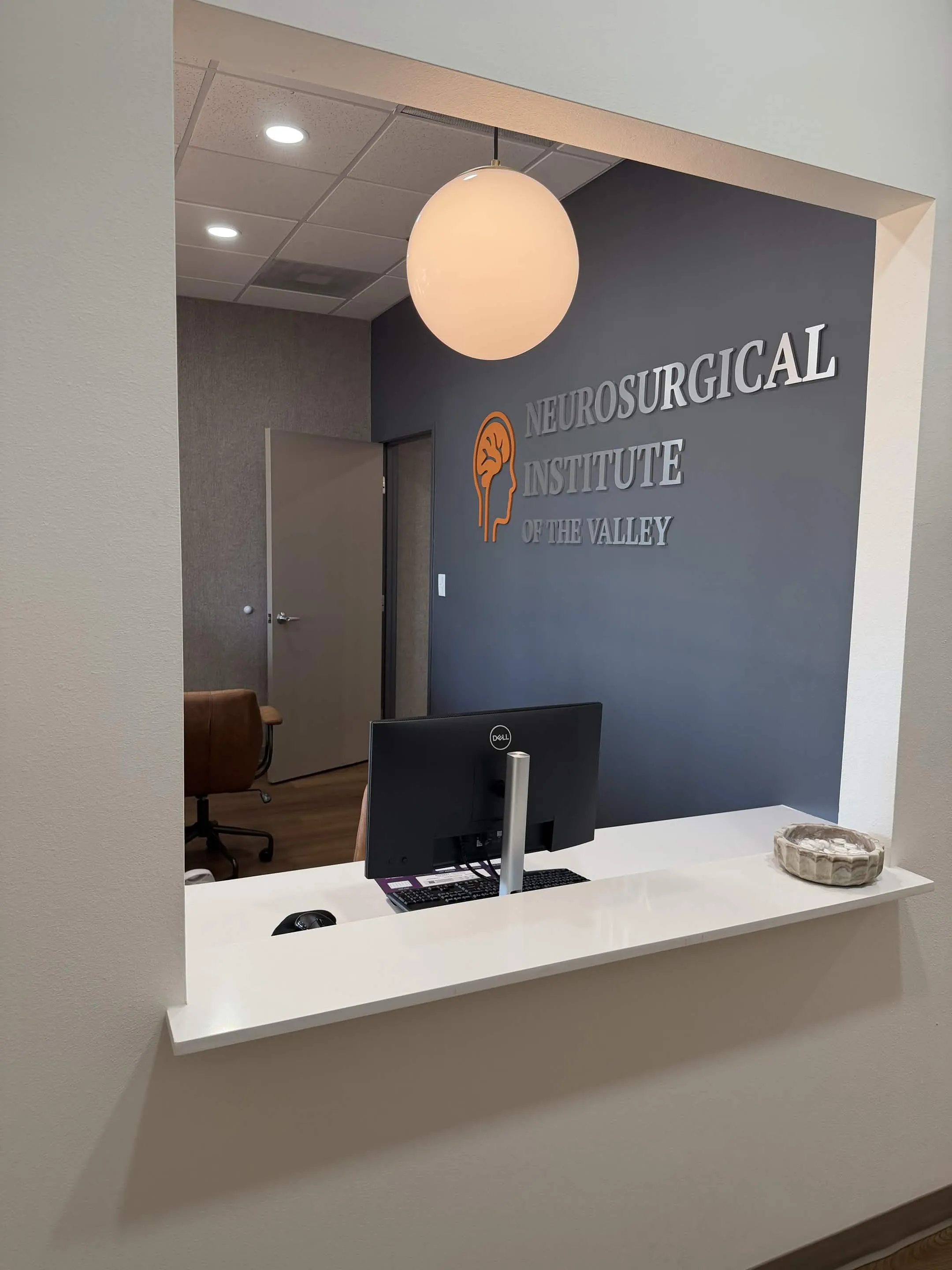 Front desk with the Neurosurgical Institute of the Valley name and logo